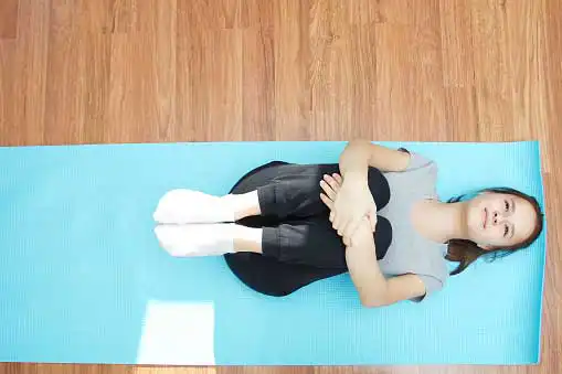 Young woman practicing on yoga mat and smiling